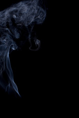 The movement of the smoke on a black background .