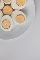 Boiled egg halves on a white plate on a light background