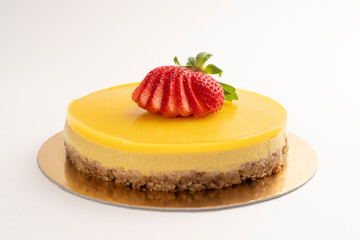 Layer mango cake with strawberries. Orange fruit cream and nuts