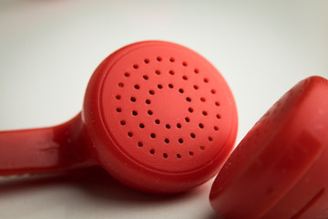macro or closeup photo of the red earphones on the white background. it can be used as technological equipment concept