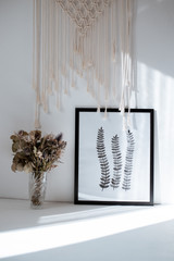 picture with black and white plants, sun shadows on the picture, picture in a black frame, on a white background
