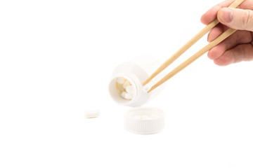 Man's hand holds chopsticks with a medical tablet.