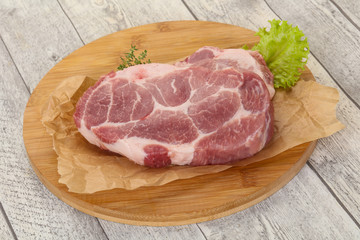 Raw pork steak over wooden board
