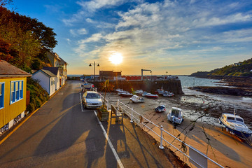 Obraz premium Image of the harbour at low tide at Rozel with small pleasure and fishing boats at sunrise. Rozel, St Martin, Jersey, Channel Islands