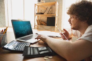 Caucasian upset and despair man watching financial and economical graphs going down during...