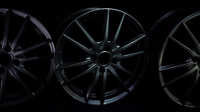 Modern aluminium or magnesium alloy wheels for car in dark background. New steel equipment for auto and vehicle. Luxury design. Expensive bright metal disks made of carbon. Clean wheels stand
