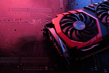 Computer game graphics card, videocard with two coolers on circuit board ,motherboard background....