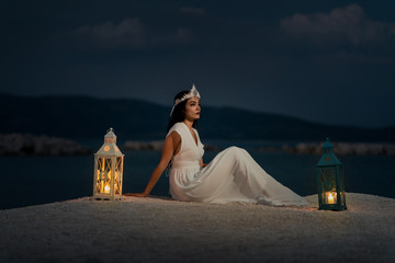 Fashion shoot with a beautiful model in an evening white dress with crown gone