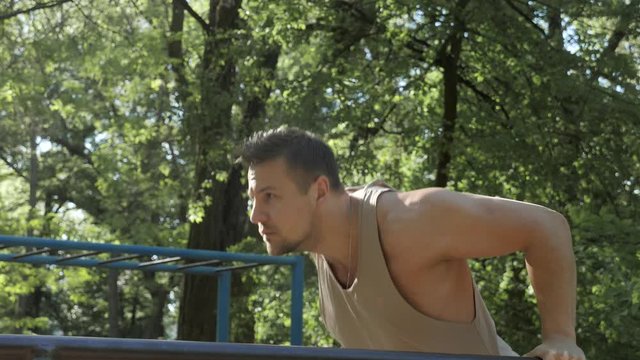 Street calisthenics exercising of an muscular athlete
