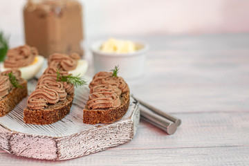 Fresh homemade chicken liver pate with carrots, onions and butter. Garnished with a sprig of dill. Lubricated on bread. On white background.