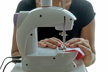 Face mask sewing: Asian woman hand sewing a fabric face mask for the coronavirus (COVID-19) and air pollution protection.