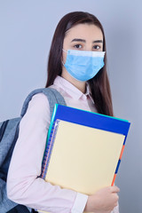 High school girl with mask on her face going back to school
