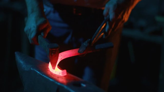 A blacksmith forging horseshoes for horses