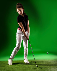 Girl looking for the perfect golf shot isolated on green background, full length