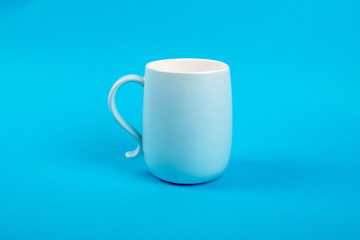 Glass cup isolated on a blue background. Dishes for drinks. Food concept.