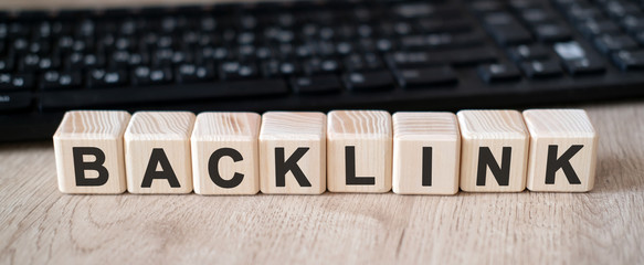 Back link - concept text on wooden cubes and in the background black keyboard