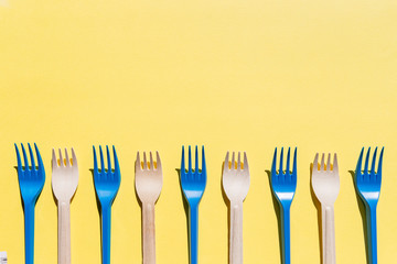 Flat lay comparison between disposable bamboo cutlery and plastic cutlery. reusable and wooden forks.recycling, eco friendly, zero waste concept, plastic-free alternatives for environmental protection