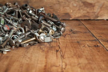 metal bolts and nuts on a wooden coating.