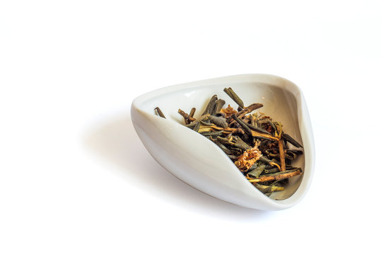 A pile of dried rhododendron Adamsia in a white bowl cha Hae, Sagan daily for tea. Isolated on a white background close up