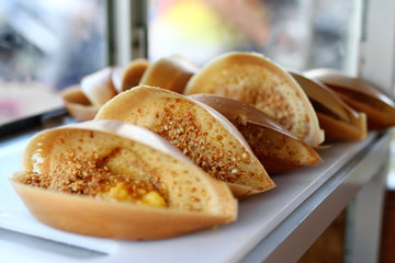 Traditional Malaysian street food apam balik - thick soft pancake with peanuts, bananas, peanut...