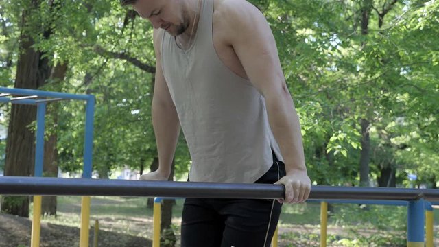 calisthenics street workout an athlete doing chest exersice on bars outdoors