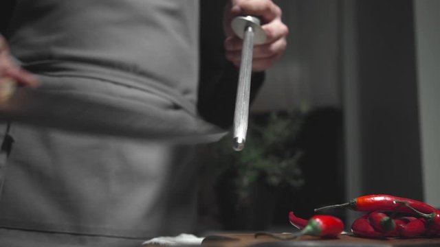 chef sharpens knife preparations for cooking food