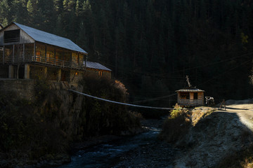 A footbridge joins a village on the other side of a river in the Tusheti region.