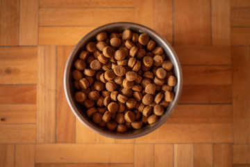 Comida de perro en un bol sobre suelo de madera