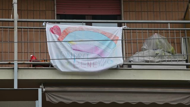 Turin, Piedmont, Italy. May 2020. Coronavirus pandemic. On the facades of the houses hang the sheets with the drawing of the rainbow and message everything will be fine. In Italian "Andr&agrave; tutto bene"