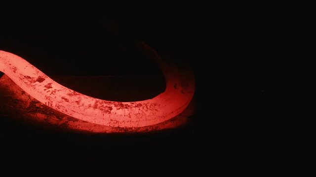 A blacksmith forging horseshoes for horses