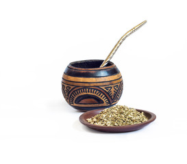 Yerba mate in calabash and dry herb in clay bowl isolated on white background