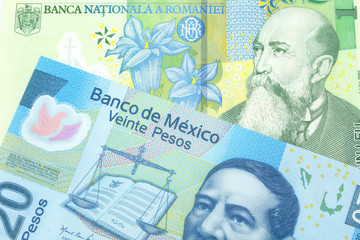 A close up image of a one Romanian leu bank note with a blue twenty peso Mexican bank note in macro