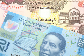 A blue, twenty Mexican peso note with a five dirham bank note from the United Arab Emirates close up in macro
