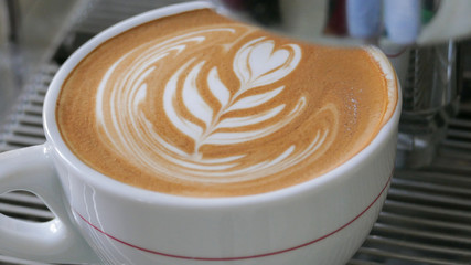 detail of prepared cappuccino with latte art on a coffee machine, coffemaker (color toned image)
