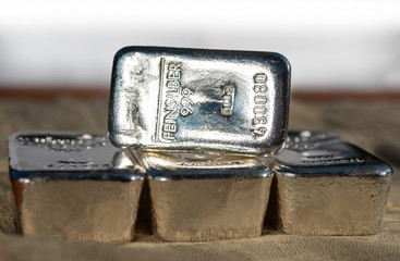 Four cast silver bars against the blured background. Selective  focus. feinsilber is fine silver.