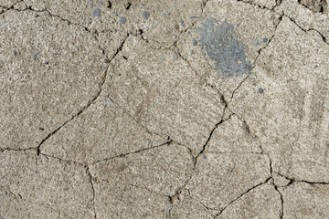 Old gray cracked cement. Large cracks in the concrete