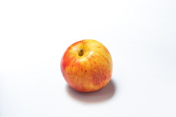 An apple with red and yellow on white background with shadow
