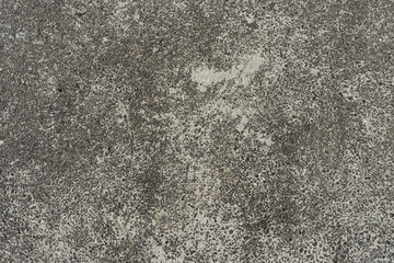 Old gray asphalt covered with sand