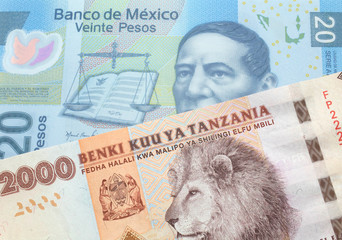 An orange and white two thousand Tanzanian shilling note with a blue Mexican peso note from Mexico...
