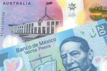A close up image of a purple, five Australian dollar note close up, in macro with a twenty peso note from Mexico
