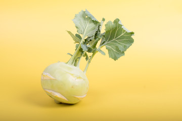 Three pieces of kohlrabi vegetable isolated on yellow simple background with copy space