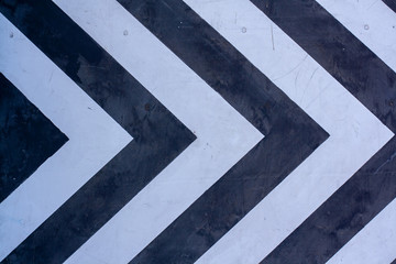 White and black pointing arrows on a wooden surface. Horizontal.