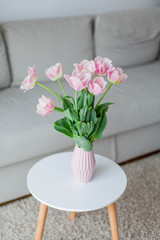 Bouquet of pink tulips in a vase in a home interior