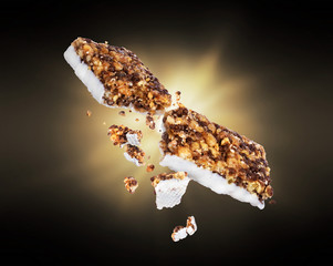 Energy cereal bars broken into two halves with a flash of light in the dark
