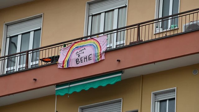 Turin, Piedmont, Italy. May 2020. Coronavirus pandemic. On the facades of the houses hang the sheets with the drawing of the rainbow and message everything will be fine. In Italian "Andr&agrave; tutto bene"