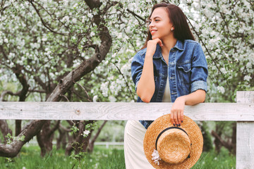 Portrait beautiful happy hipster woman in stylish dress and long hair posing on wooden fence on...