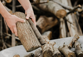 Men's hands close-up put sawn-off logs. Ecological and forestry concept. Logs for the bath. Household chores.  - obrazy, fototapety, plakaty