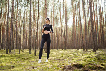 Sporty woman outdoors. Girl resting after training in the woods. Exhausted caucasian jogger girl...