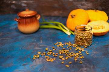 Clay pot of pumpkin soup on napkin over white textured background, close-up, selective focus, top view.