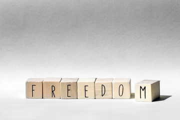 Wooden cubes with the word Freedom, Freedom concept background close-up